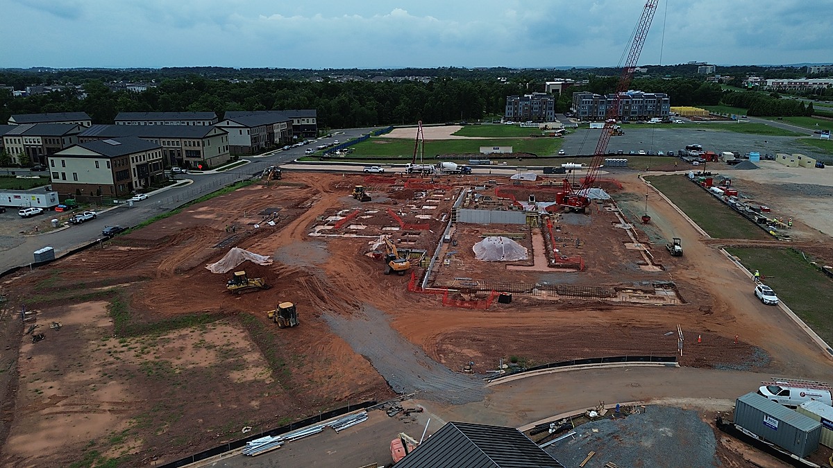 Aerial view of an active construction foundation with rebar and crane in Loudoun County