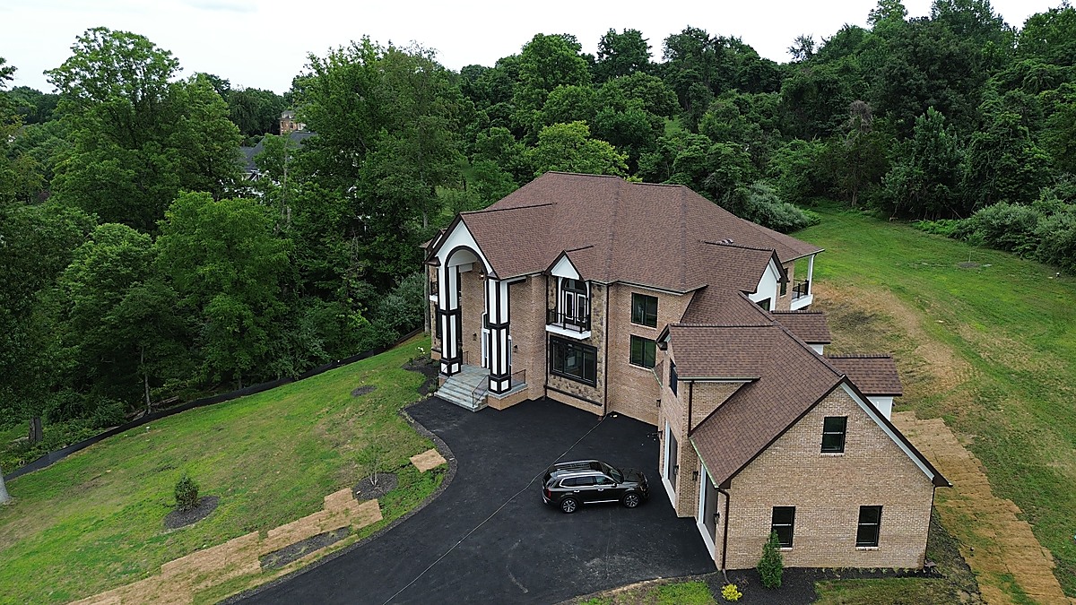 Front aerial view of a new construction brick colonial with arched entrance in Northern Virginia